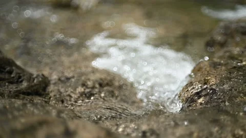 Water flows over rocks in summer sunlight (bokeh, slow motion) Stock-Footage 219634542