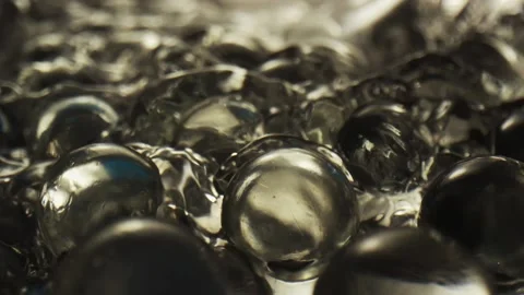 Water flows over transparent spheres in beautiful light Stock Footage 165035710