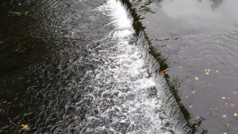 Water flows over a weir in the river Stock Footage 102586712