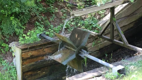 Water flows over a wooden mill wheel Stock Footage 340909039