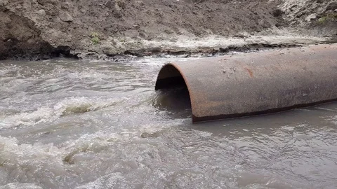 Water flows from the pipe into the river Stock Footage 97641593