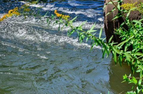 Water flows from the pipe into the river. Foto stock
