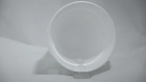 Water flows from a polystyrene cup and puddles in front of it Stock Footage 263078622