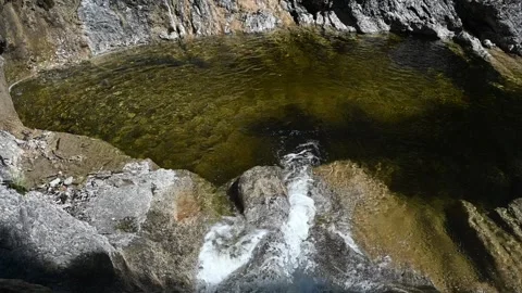 Water flows into a pool from a mountain stream (slow motion) Stock Footage 219646160