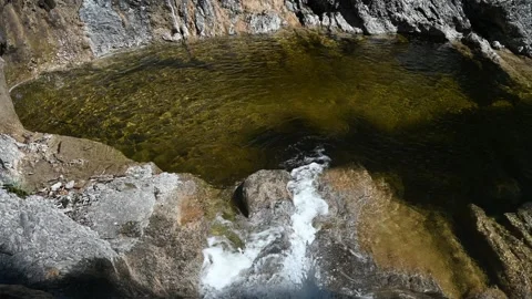 Water flows into a pool from a mountain stream Stock Footage 219646243