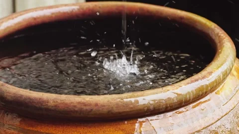 Water flows from the rain gutter into the jar. Stock Footage 169209436