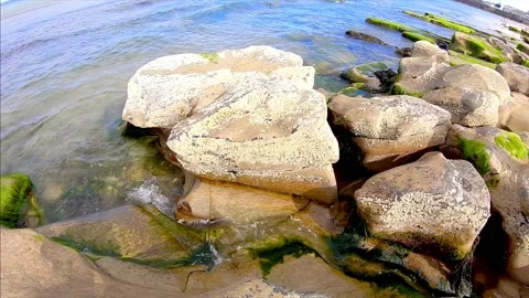 Water flows from a rock at the beach Stock Footage 132576811