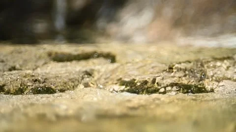 Water flows in a rocky mountain river (slow motion, bokeh) Video stock 212747409
