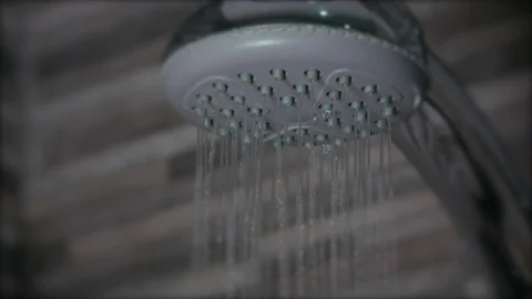 Water flows from shower head close up, shallow focus Vídeos de archivo 105157828