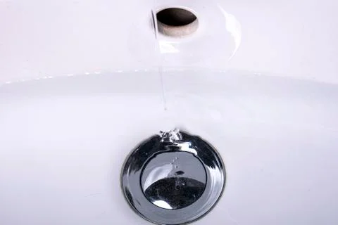 Water flows into the sink with drain plug Stock Photos