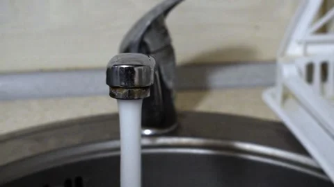 Water flows into the sink from a fully open faucet. Stock Footage 315650880
