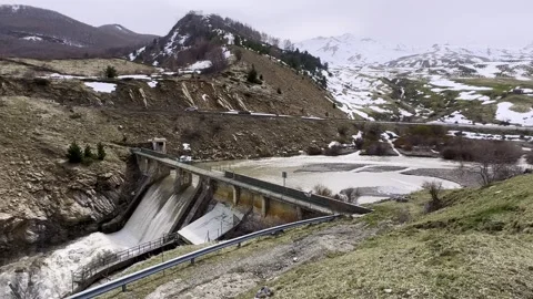 The water flows from the snow-capped mountain to a hydroelectric dam. Stock Footage 272327757