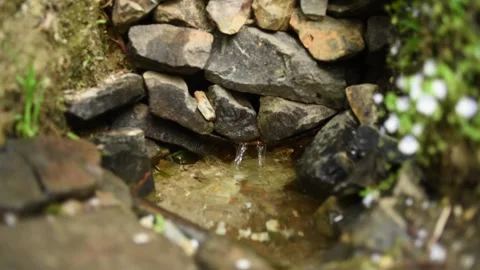 Water flows in a spring lined with stones Stock Footage 130198319