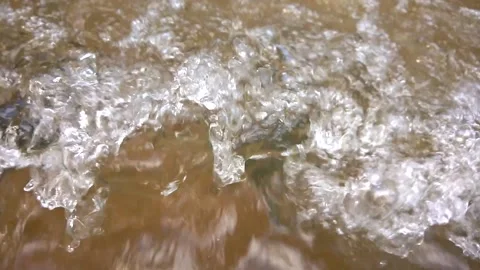 Water flows in stream close-up range, with water droplets on the surface. Stock Footage 167618212