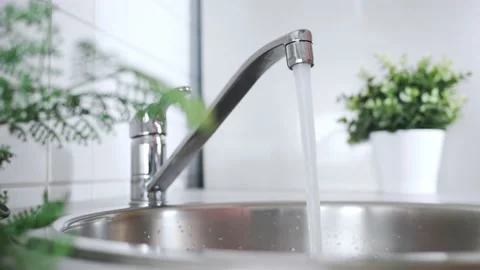 Water flows from tap in controlled stream, emphasizing responsible water 스톡 동영상 233018324