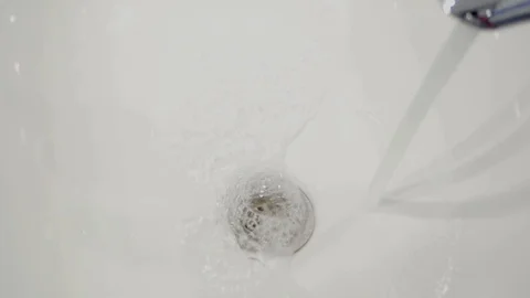 Water flows from the tap into the sink Stock Footage 98134648