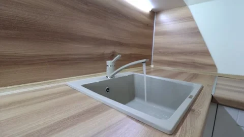 Water flows from the tap into the sink . Kitchen sink. The sink is ceramic. Stock Footage 142466973