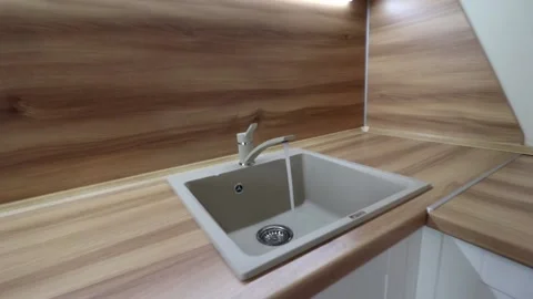Water flows from the tap into the sink . Kitchen sink. The sink is ceramic. Stock Footage 142467022