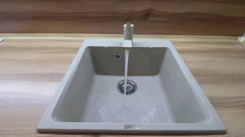 Water flows from the tap into the sink . Kitchen sink. The sink is ceramic. Stock Footage 143559901
