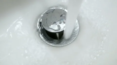 Water flows from the tap to the white sink Stock Footage 105874877