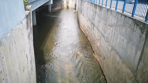 Water flows through concrete drainage ditches. Selective focus Stock Footage 125650163