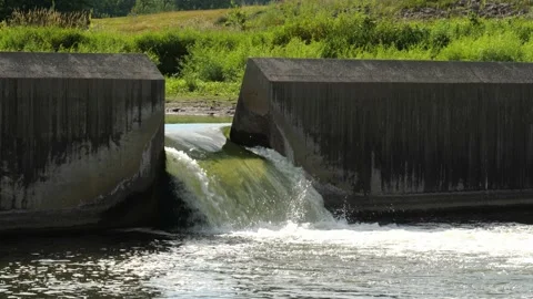 Water flows through the floodgate in a concrete dam on a river. Stock Footage 146715524