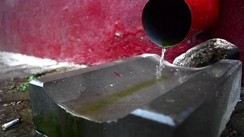 Water that flows through a gutter on the pavement in the yard while torrentia Video stock 78219299