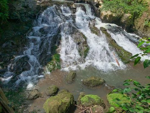 The water flows through the rocks in the middle of the forest. Small waterfal Stock Photos