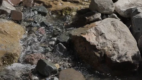 The water flows through the rocks in the mountains Video stock 77936838