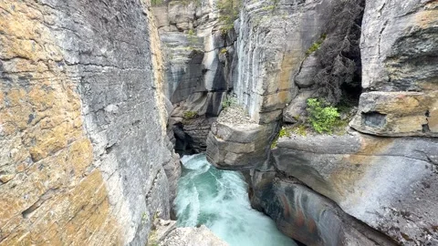 Water flows through the rocks in a narrow canyon at a natural site in Canada Vídeos de archivo 345232457