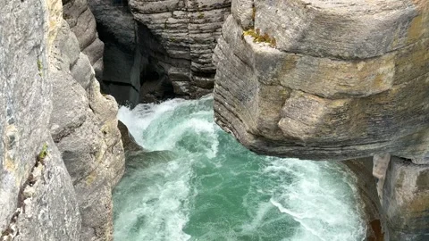 Water flows through the rocks in a narrow canyon at a natural site in Canada Vídeos de archivo 345232460