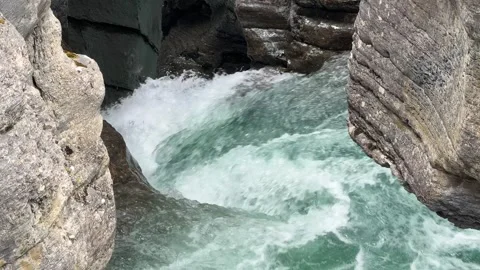 Water flows through the rocks in a narrow canyon at a natural site in Canada Vídeos de archivo 345232461