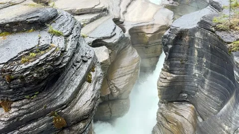 Water flows through the rocks in a narrow canyon at a natural site in Canada Vídeos de archivo 345232463