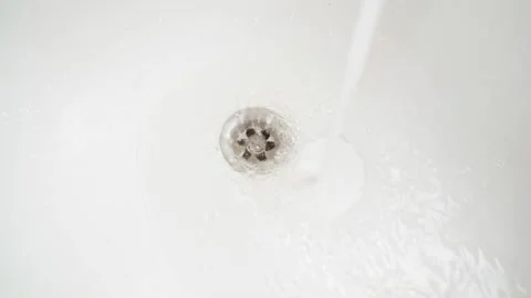 Water flows under pressure into the bathroom and a water funnel merges into the Stock Footage 172915894