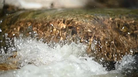 Water flushing over rocks in a mountain stream (slow motion, bokeh) 스톡 동영상 219391358
