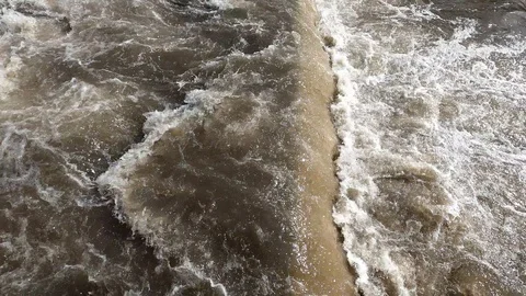 The water foams because of the rapid current at the bottom of the slope. Video stock 126333246