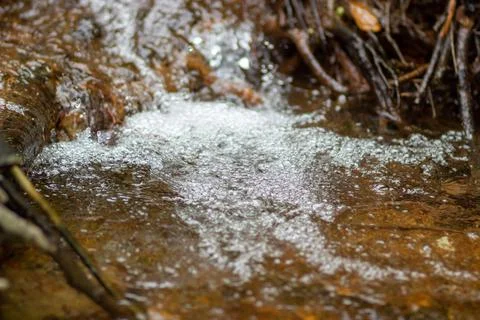 Water in the form of bubbles flows down the stones Stock Photos