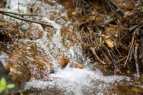 Water in the form of bubbles flows down the stones Stock Photos