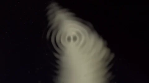 Water forming cymatic patterns and reflecting light. Fluid surface under Stock Footage 111958041