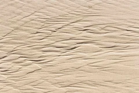 Water forms spectacular patterns at the sandy beach 스톡 사진