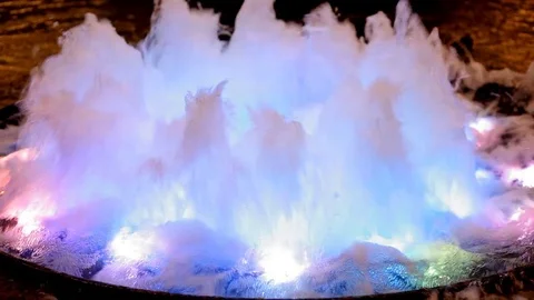 The water in the fountain bubbling in multi-colored rays of light. Video stock 70148331
