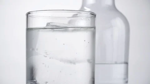Water in a Glass with clear ice cubes and a Bottle Stock Footage 123723640