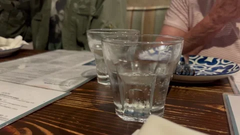 Water Glasses on Restaurant Dining Table with People Moving in Background Vídeos de archivo 342194709