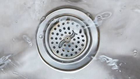 Water going down drain in stainless steel kitchen sink. Hand opens drain HD. Stock Footage 104108844