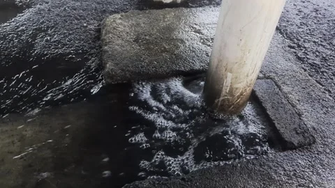 Water Gushing from Drainage Pipe Under Concrete Pillar in Urban Area Stock Footage 328714035