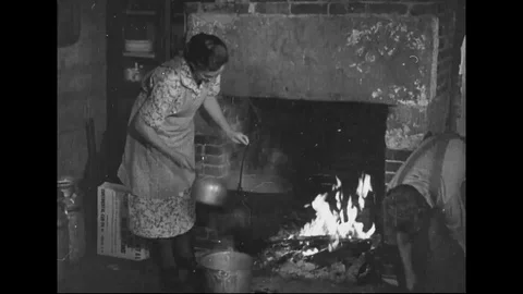Water is heated over a fire and used with a tub and washboard to launder clothes Stock Footage