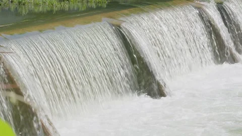 Water from heavy rainfall flowing over small dam on Texas river Stock Footage 335598531