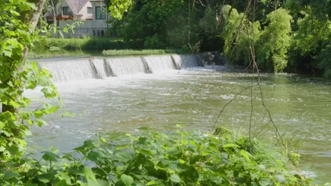 Water from heavy rainfall flwing over small dam on Texas river Stock Footage 335597584