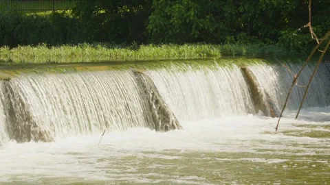 Water from heavy rainfall runs over small dam on Texas river Stock Footage 335597415