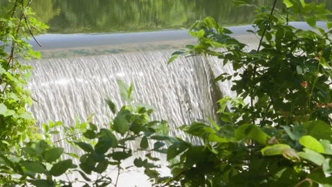 Water from heavy rainfall runs over small dam on Texas river Stock Footage 335597671